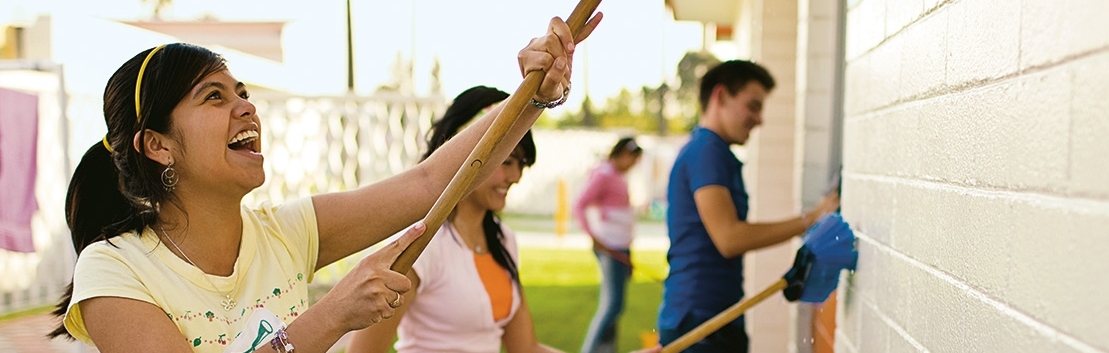 Youth painting a community building